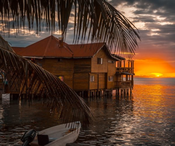 Sunset in the West End wooden building on Roatan Island Roatán, Honduras »; January 2020: A young woman walking at sunset in the West End wooden building on Roatan Island